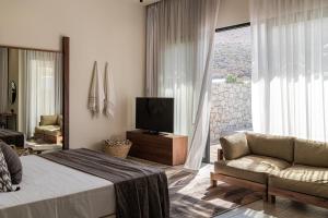 
a living room filled with furniture and a tv at Casa Cook Rhodes (Adults Only) in Kolimbia
