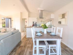 a kitchen and living room with a table and chairs at Beech Lodge in Newton Abbot