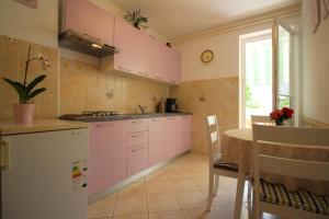 cocina con armarios rosas y mesa en Apartment Radojka L near city centre, en Poreč