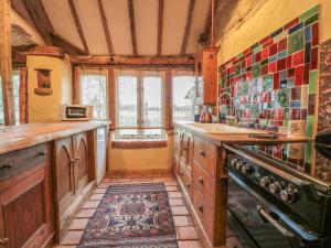 a kitchen with wooden cabinets and a rug on the floor at Jackdaw's Roost in Gloucester