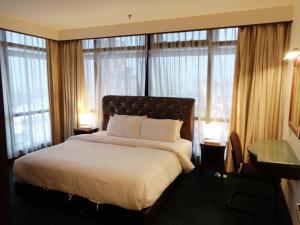 a bedroom with a large bed with windows at Kl Raymond Apartment At Time's Square in Kuala Lumpur