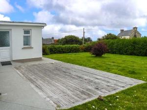a backyard with a house and a grass yard at Ocean View in Ballinskelligs