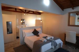 a bedroom with a bed with two stuffed animals on it at The Mole Guesthouse in Swakopmund