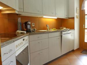 a kitchen with white cabinets and a counter top at Apartment Casa La Planüra by Interhome in Maloja