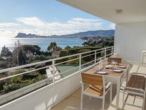 een balkon met een tafel en stoelen en uitzicht op het water bij Apartment Les Hauts de Fonsainte by Interhome in La Ciotat