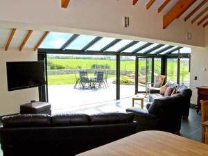 a living room with a couch and a television at Garth Morthin The Barn in Morfa Bychan