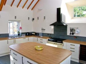 a kitchen with a wooden counter top in a room at Garth Morthin The Barn in Morfa Bychan