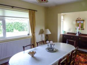 a dining room with a white table and a window at Eileen's in Cloone