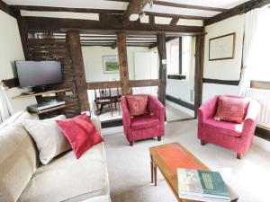 ein Wohnzimmer mit zwei Stühlen und einem Fernseher in der Unterkunft Causeway Cottage in Pencombe
