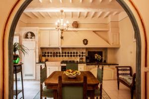 eine Küche mit einem Tisch und einer Obstschale darauf in der Unterkunft Palazzo Barbini Dimora Storica in Castiglione del Lago