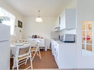 a kitchen with white appliances and a table and chairs at Studio Les Corniches du Mont Canisy-3 by Interhome in Blonville-sur-Mer