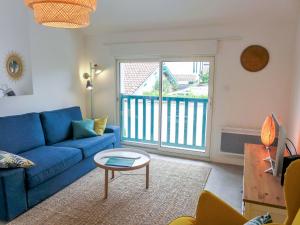 uma sala de estar com um sofá azul e uma mesa em Apartment Elaura by Interhome em Biarritz