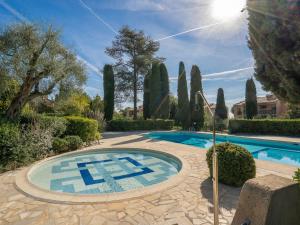a swimming pool in a garden with a tile design on the ground at Apartment L'Orée de Vence by Interhome in Vence