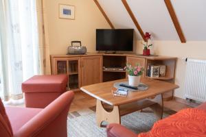 a living room with a tv and a coffee table at Haus Sabine - OG in Groß Kirr