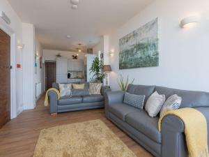 a living room with two couches and a kitchen at Hepworth Apartment in St Ives
