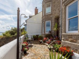 a house with a patio and flowers in front of it at Hepworth Apartment in St Ives
