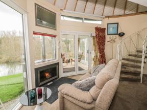a living room with a couch and a fireplace at Secret Island Yurt in Beckford