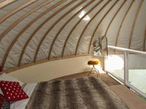 een kamer met een groot bed in een yurt bij Secret Island Yurt in Beckford