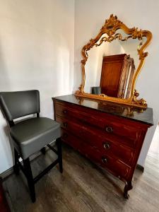 un tocador con una silla y un espejo. en Apartament na Maja -2-, en Skierniewice