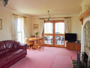 a living room with a couch and a table at Colbha Cottage in Portsalon