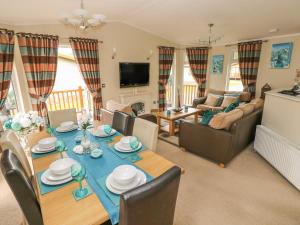 a dining room and living room with a table and chairs at Heddwch in Stepaside