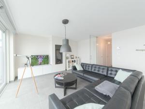 ein Wohnzimmer mit einem Sofa und einem Tisch in der Unterkunft Apartment Lakeside by Interhome in Bredene
