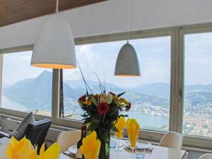 a table with a vase of flowers and two lights at Holiday Home Nido di Rondine-1 by Interhome in Viganello