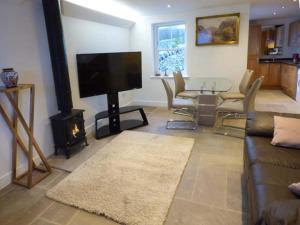 a living room with a television and a fireplace at 3 Primitive Croft in Chelmorton