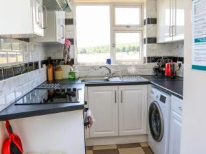 uma cozinha branca com um lavatório e uma máquina de lavar louça em Clash-Brack em Dungarvan