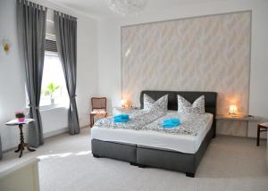 a bedroom with a large bed with blue pillows at Zach Family in Lübbenau