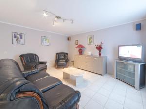 ein Wohnzimmer mit 2 Ledersofas und einem TV in der Unterkunft Holiday Home New Village Park-5 by Interhome in Mispelburg