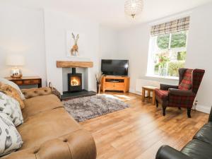 uma sala de estar com um sofá e uma lareira em 2 Moor Farm Cottages em Flinton