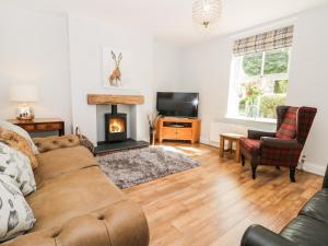 a living room with a couch and a fireplace at 2 Moor Farm Cottages in Flinton