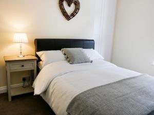 a bedroom with a bed with a heart mirror on the wall at 2 Moor Farm Cottages in Flinton