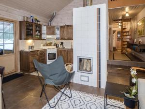 uma cozinha com uma cadeira e uma lareira em Holiday Home Koliwood b by Interhome em Kolinkylä