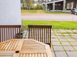 2 bancs en bois assis sur une terrasse avec une table dans l'établissement Holiday Home Hiisiranta c3 by Interhome, à Hattusaari
