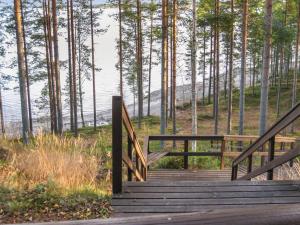 a wooden staircase leading to a boardwalk with trees at Holiday Home Mäkrä 1 by Interhome in Kolinkylä