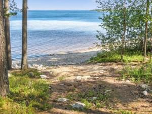 a beach with trees and water in the background at Holiday Home Mäkrä 1 by Interhome in Kolinkylä