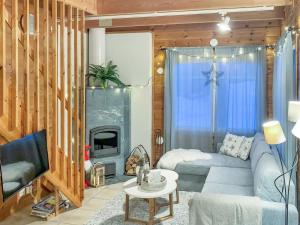 ein Wohnzimmer mit Couch und Kamin in der Unterkunft Holiday Home Saunaharju 3 by Interhome in Kolinkylä