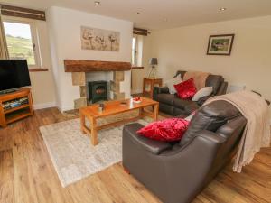 a living room with a couch and a fireplace at Meadow Cottage in Keighley