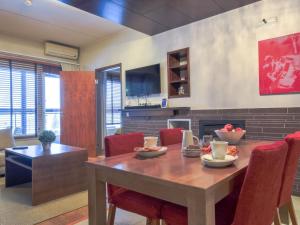 ein Esszimmer mit einem Holztisch und roten Stühlen in der Unterkunft Holiday Home Tahko spa junior suite orange b6 by Interhome in Tahkovuori