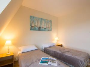 2 Betten in einem Zimmer mit 2 Lampen und einem Buch in der Unterkunft Apartment Le Polo by Interhome in Deauville