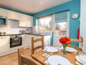 eine Küche mit einem Tisch und Stühlen sowie eine Küche mit blauen Wänden in der Unterkunft 17 Fewster Way in York