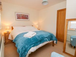 ein Schlafzimmer mit einem Bett mit einer blauen Decke darauf in der Unterkunft 17 Fewster Way in York