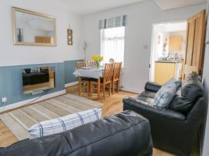 a living room with a couch and a table at Sea Breakers Cottage in Filey
