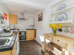 a kitchen with a counter with yellow flowers in a vase at Sea Breakers Cottage in Filey +11 photos