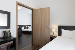 
a bedroom with a bed and a dresser at Apart Hotel Imeretinsky - Pribrezhny Kvartal in Adler
