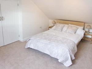a bedroom with a large bed with white sheets and pillows at Kipper's Corner in Doveridge