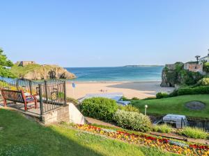 Una vista de una playa con un banco y el océano. en 5 Park Place, en Tenby