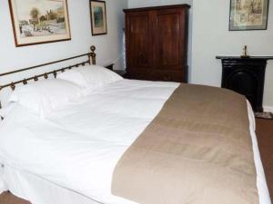 a large white bed in a bedroom with a fireplace at Clock View in Haworth